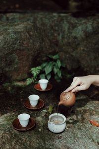 Hand holding tea cup on table