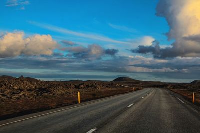 Empty road against cloudy sky