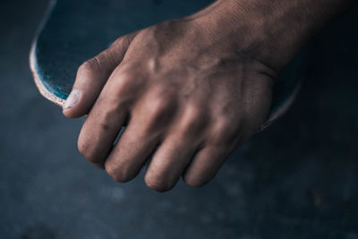 Cropped hand holding skateboard