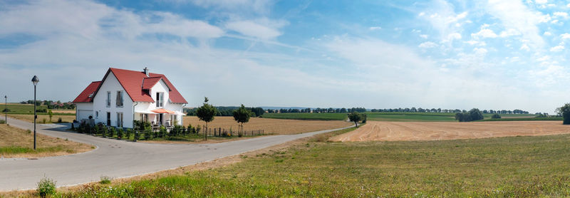 Road amidst field against sky