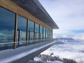 Built structure on snow covered mountain against sky