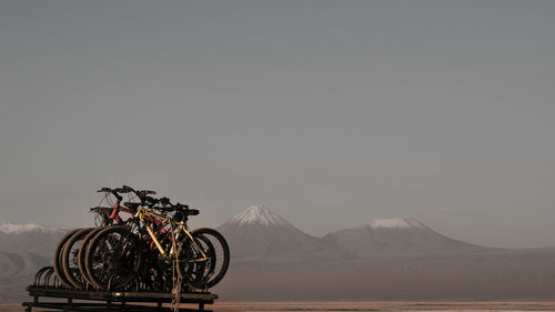 Bicycles on landscape against clear sky