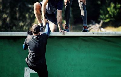 Rear view of men climbing wall