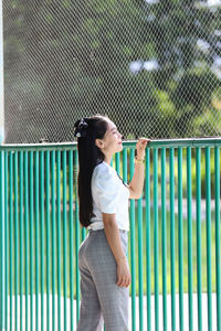 Full length of woman standing against railing