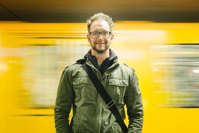 Portrait of happy man standing in bus