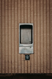 Stainless steel fountain in beige wall.