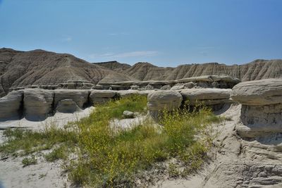 Scenic view of land and rock formations against sky