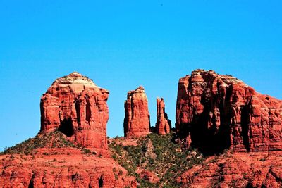 Rock formations on mountain against blue sky