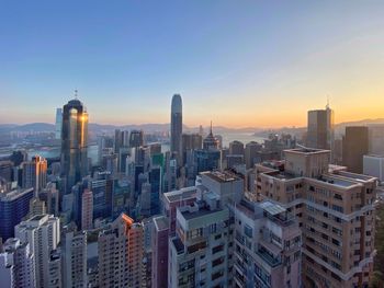 Aerial view of buildings in city at sunset