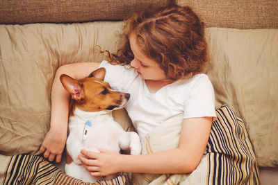 Sick baby girl and puppy under quilt with fever and temperature.