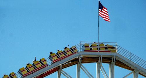 Low angle view of flags against clear blue sky