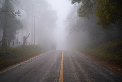 Road amidst trees against sky