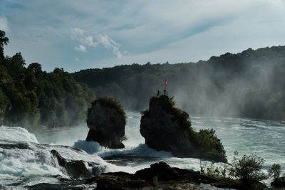 Scenic view of waterfall against sky
