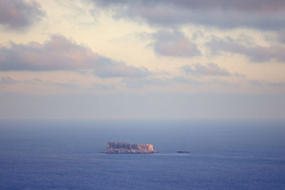 Isolated rocky island in the middle of the sea.