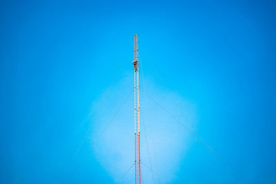 Low angle view of communications tower against blue sky