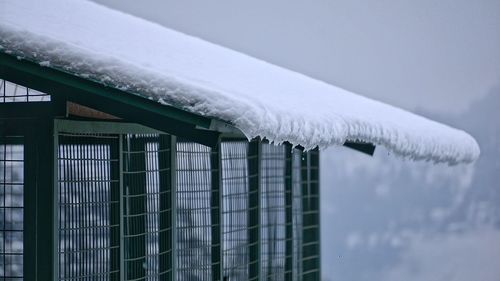 Close-up of snow on roof against sky