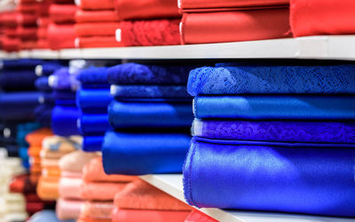 Full frame shot of multi colored rolled up fabrics for sale on shelves