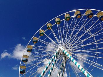 Low angle view of ferris wheel against blue sky