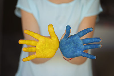 Child's hands painted on ukraine flag colors. peace for ukraine. stop war in ukraine.