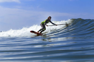 Female sup surfer on a wave