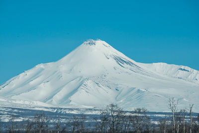 Scenic view of snowcapped mountain against blue sky