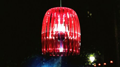 Low angle view of illuminated light bulb against black background