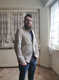 Portrait of young man standing at home