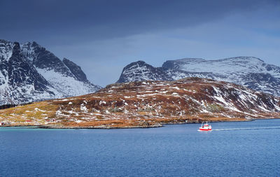 Scenic view of ship in sea against mountain range