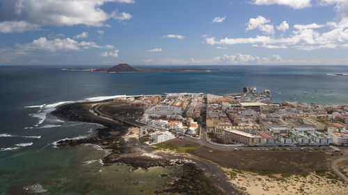 High angle view of townscape by sea against sky