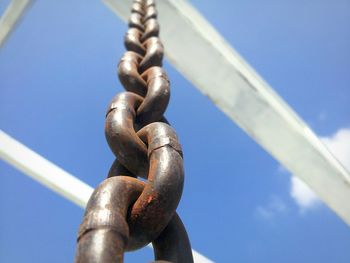 Low angle view of chain against blue sky