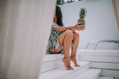 Midsection of woman sitting at home