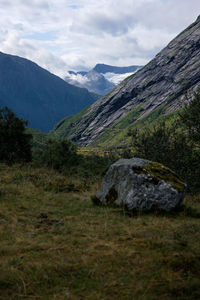 Scenic view of green landscape and mountains against sky