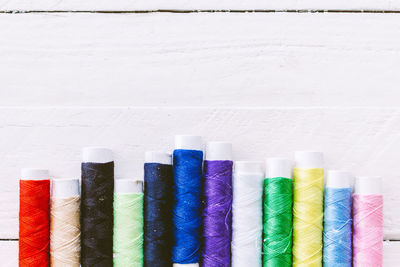 Close-up of colorful threads arranged on wooden table