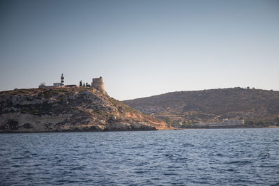 Scenic view of sea and buildings against clear sky