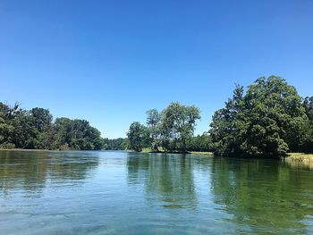 Scenic view of lake against clear blue sky