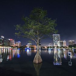 Illuminated cityscape against sky at night