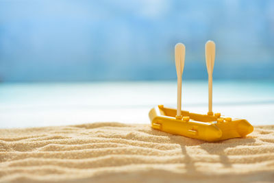 Close-up of yellow umbrella on beach