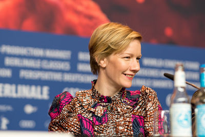 Close-up of smiling young woman against blurred background