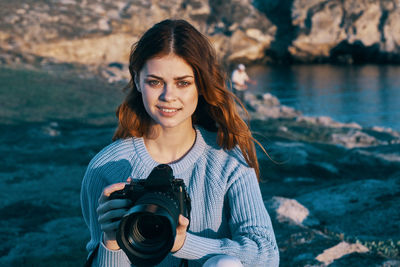 Portrait of young woman photographing