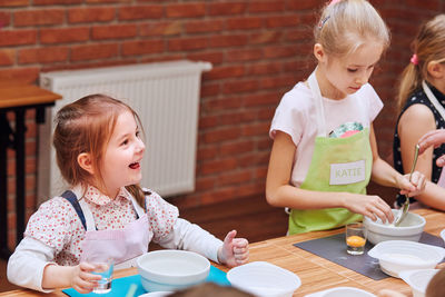 Girls preparing cake in classroom