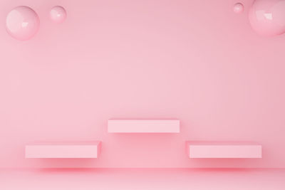 Low angle view of pink balloons against wall