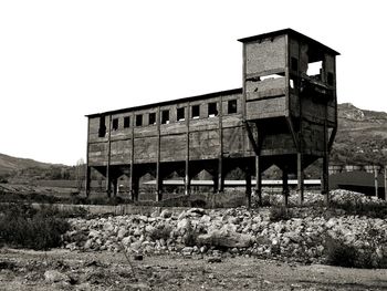 Abandoned house on field against clear sky