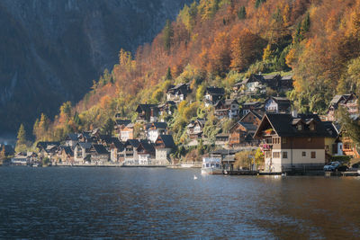 Houses by trees and buildings against mountain during autumn