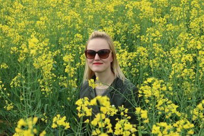 Woman standing in field of yellow flowers