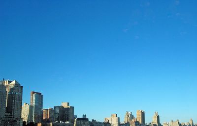 Panoramic view of buildings against clear blue sky