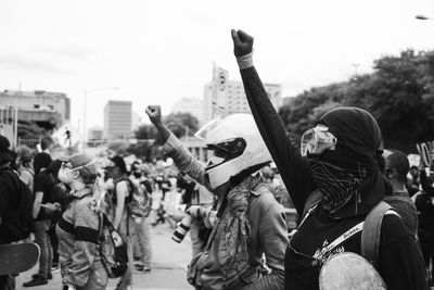 People on street in city against sky