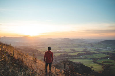 Amazing moment at sunrise as a hiker celebrates his climb up the mountain and completing 