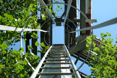 Directly below shot of ladder at metal structure against clear sky