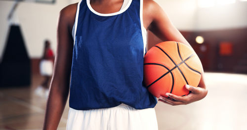 Midsection of woman playing basketball