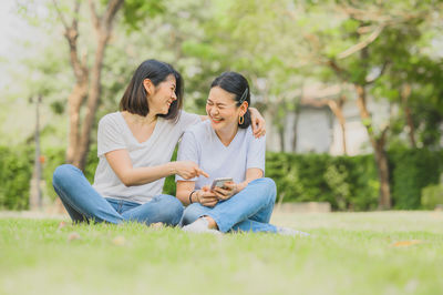 Surface level view of smiling woman sitting on grass outdoors